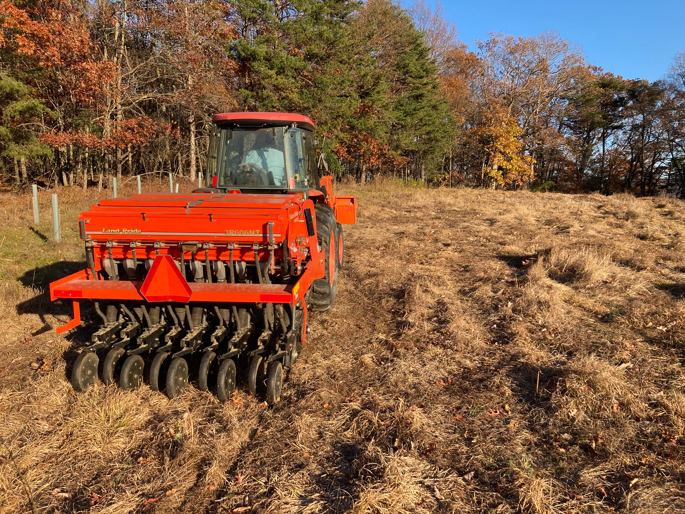 Red Seed Drill in field with tree shelters